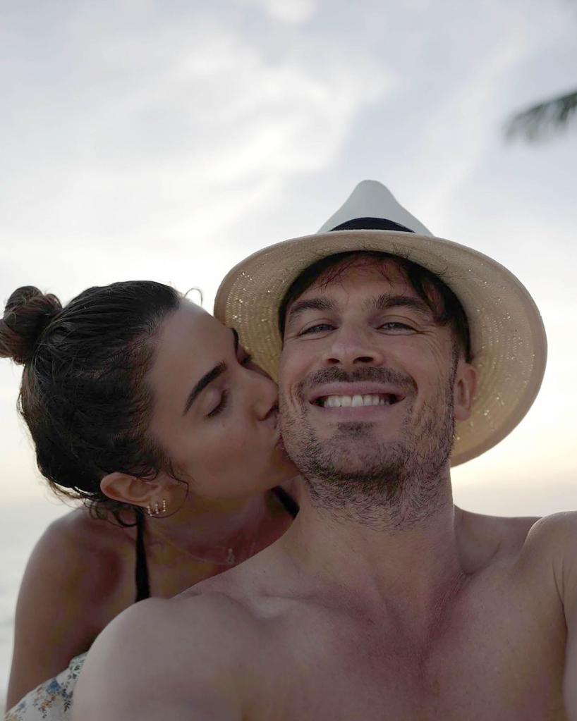 A selfie of Nikki Reed kissing Ian Somerhalder's cheek as he smiles in a hat.