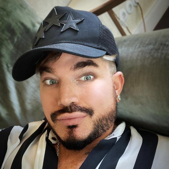 A selfie of Adam Lambert wearing a baseball cap.