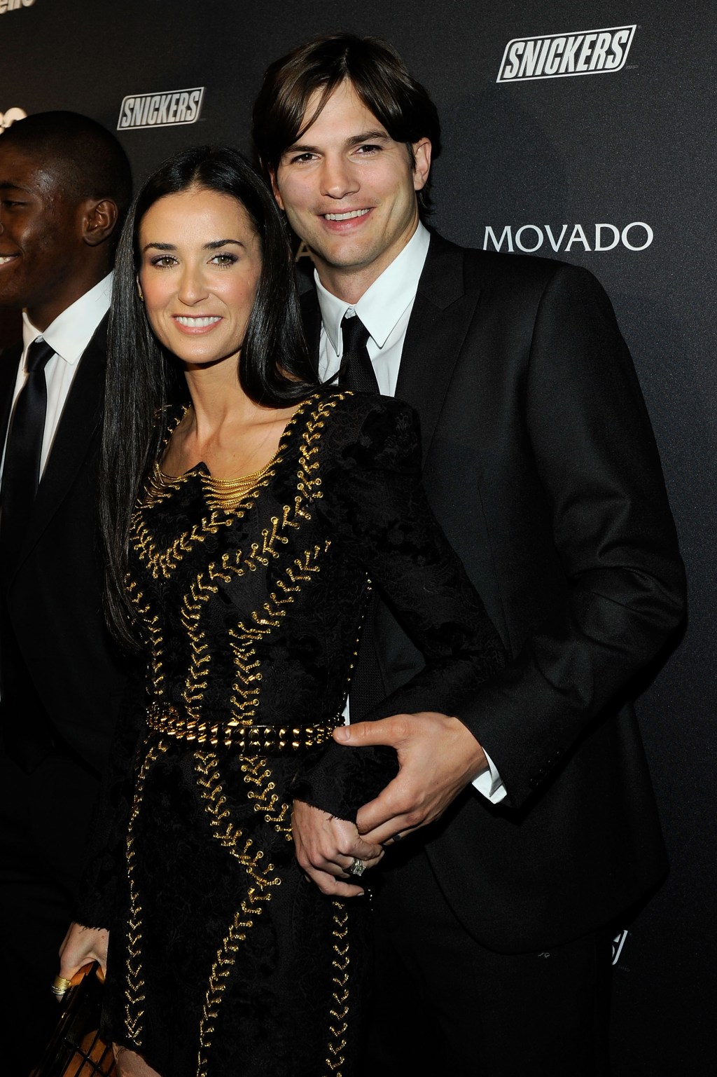 Demi Moore smiles with Ashton Kutcher on red carpet, both wearing black