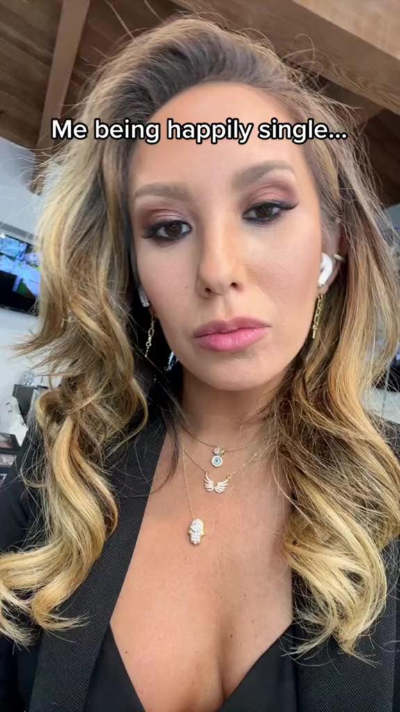 A screenshot of Cheryl Burke in a TikTok video with "Me being happily single..." written over her head.