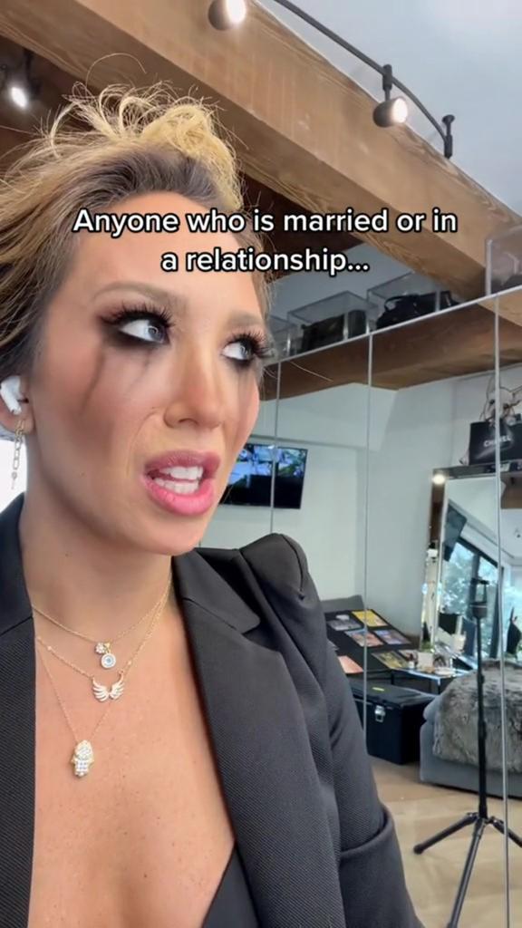 A screenshot of Cheryl Burke in a TikTok video with a filter that makes it look like makeup is running down her face.