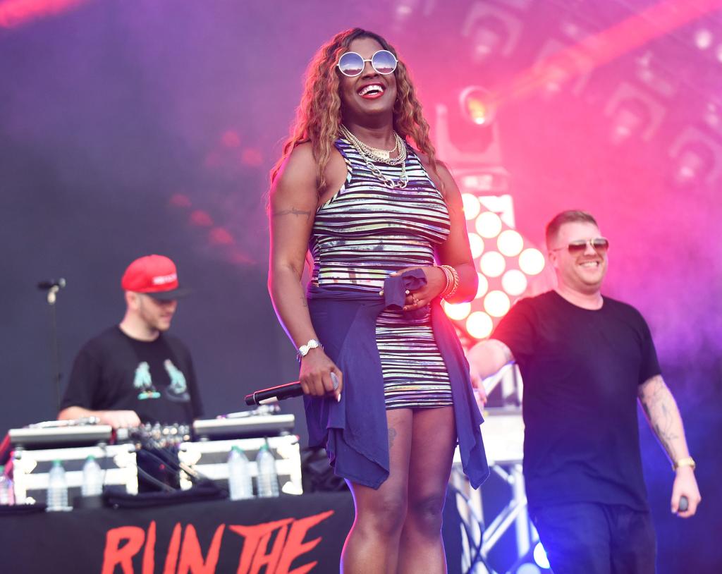 Gangsta Boo smiling on a stage.