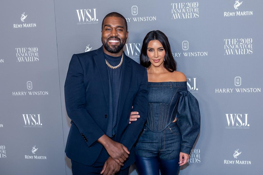 Kanye West and Kim Kardashian posing together on a red carpet.