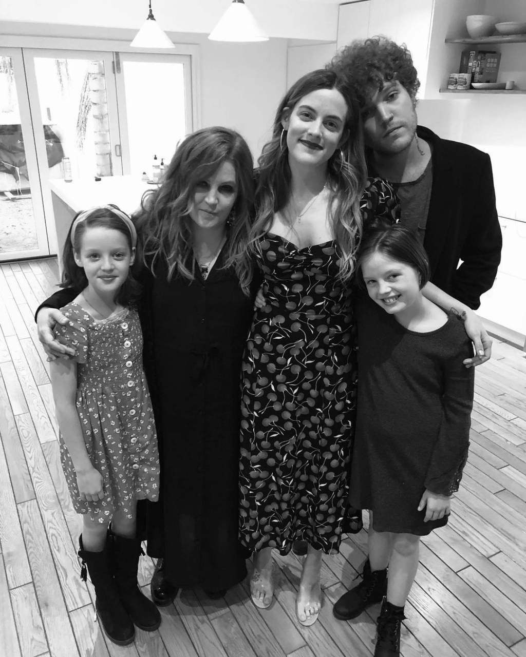 Lisa Marie Presley stands with twins Harper and Finley, daughter Riley and son Benjamin in black-and-white photo