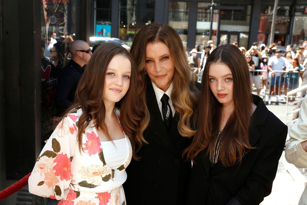 Lisa Marie Presley smiles between twin daughters Harper and Finley