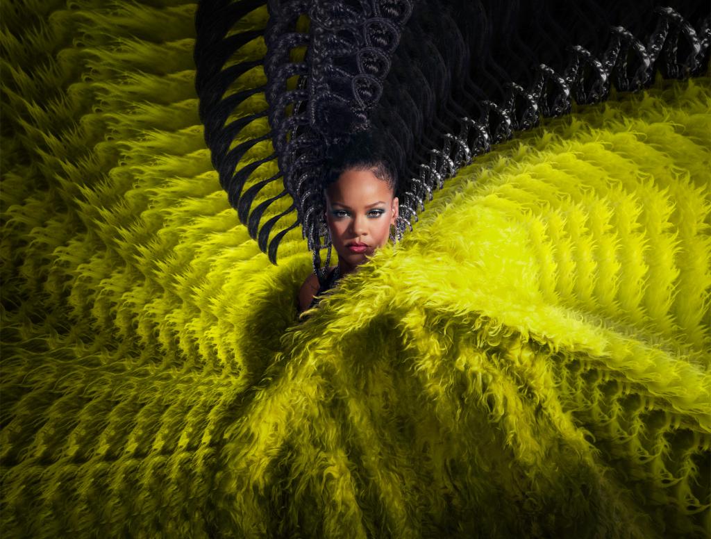 Rihanna surrounded by green feathers.