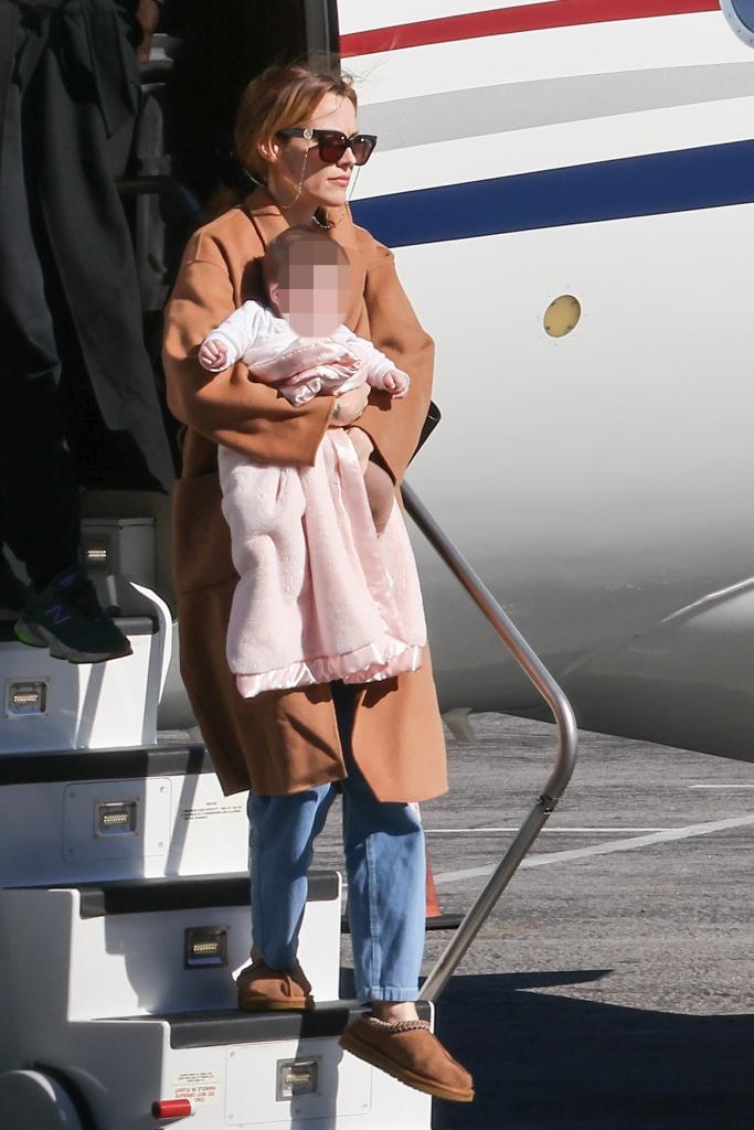 Riley Keough carrying her daughter