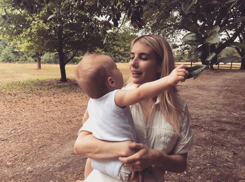 Emma Roberts holds son Rhodes while standing outside