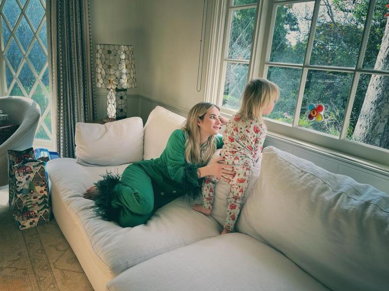 Emma Roberts sits on couch with son Rhodes in pajamas