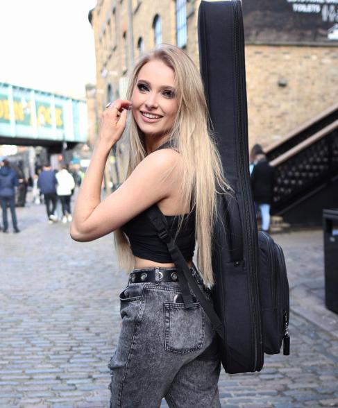 Sophie Lloyd looking back at the camera in a black crop top and jeans.