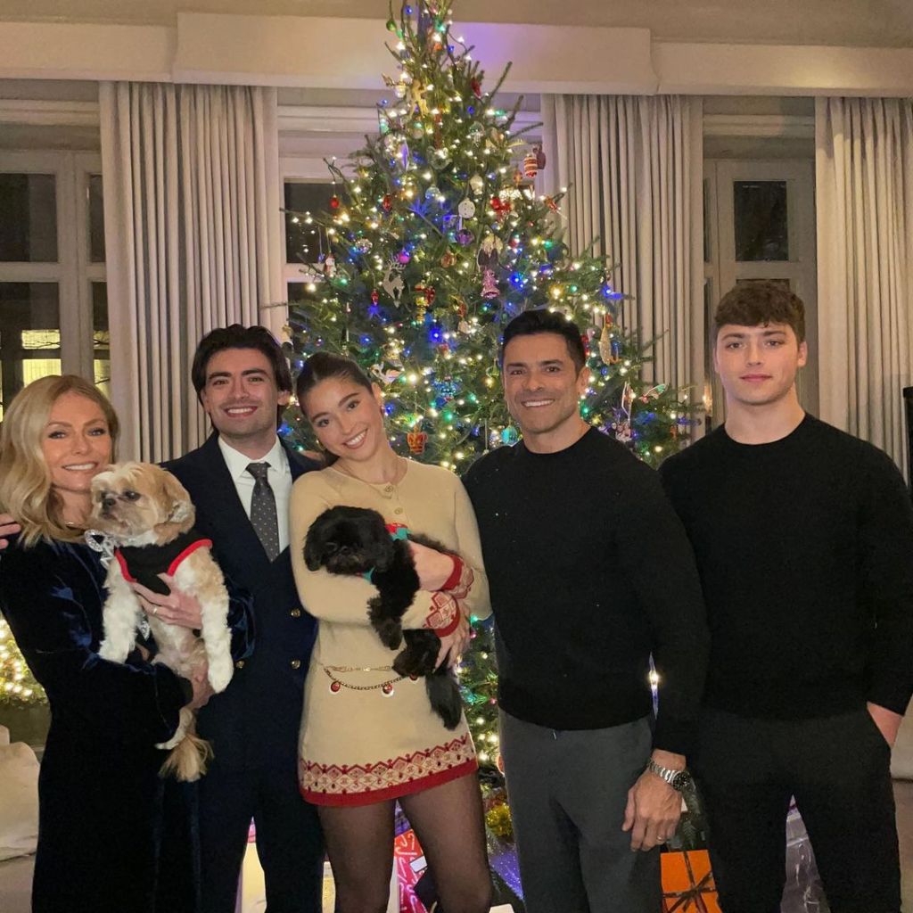 Kelly Ripa, Mark Consuelos and their three kids in front of the Christmas tree. 