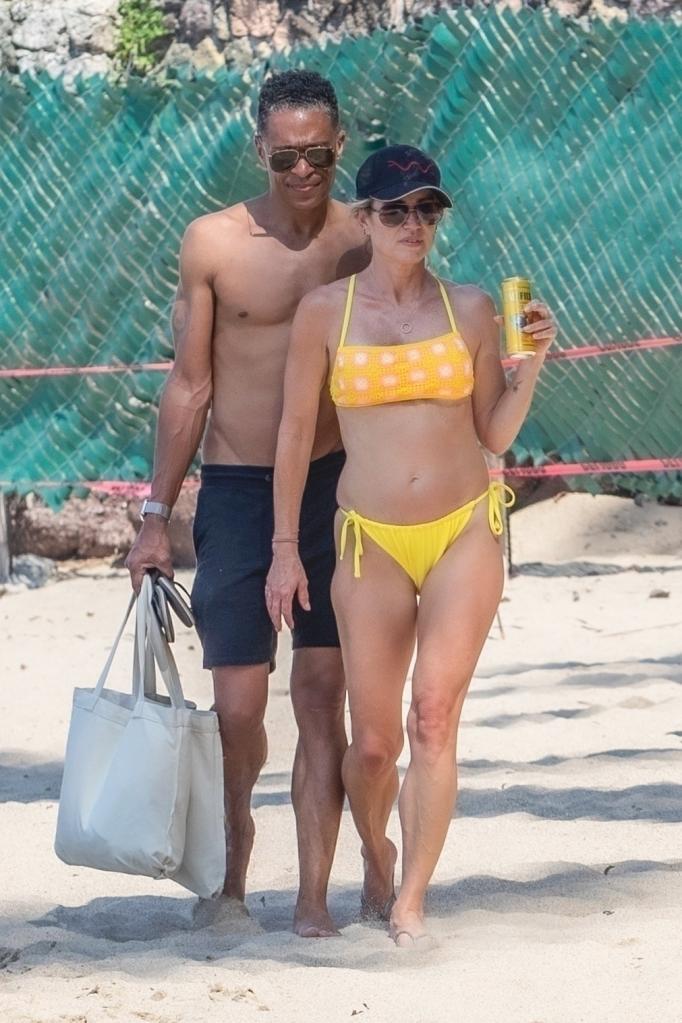 T.J. Holmes and Amy Robach walking on a beach together.