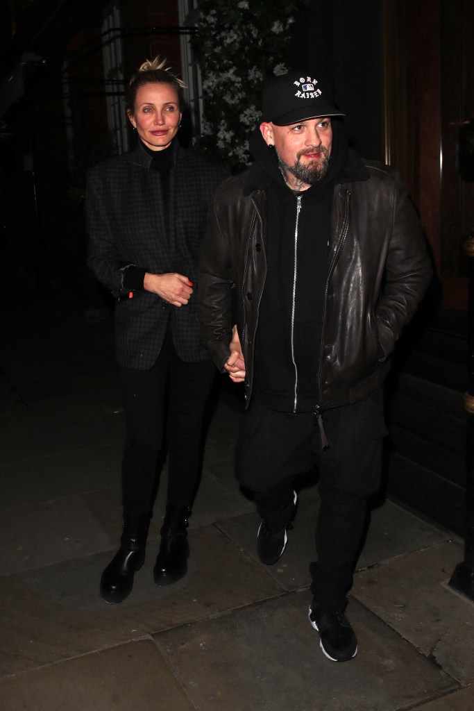 Cameron Diaz and Benji Madden holding hands.