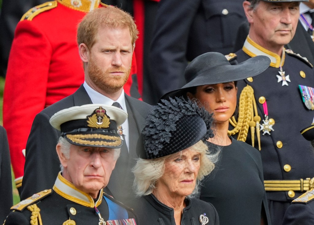 Prince Harry, Meghan Markle, King Charles III and Queen Consort Camilla standing together.