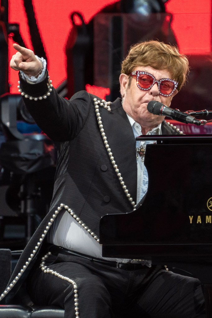 Elton John playing a piano.