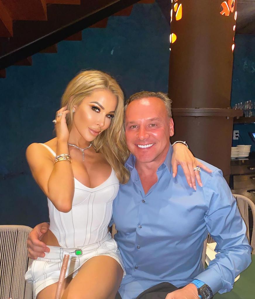 Lisa Hochstein sitting on Lenny Hochstein's lap as they pose for a photo together.