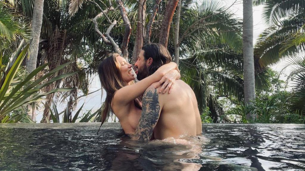 Sonni Pacheco and Nathan Thompson hug in pool
