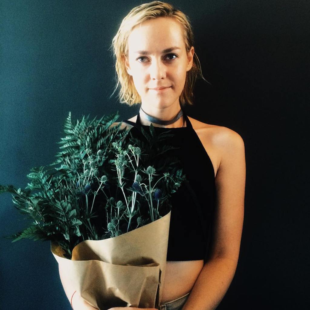 Jena Malone holding a flower pot.