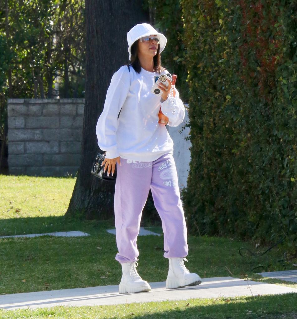 Scheana Shay walking with a bucket hat outside.