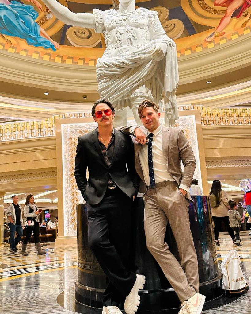 tom sandoval and tom schwartz posing in front of a statue