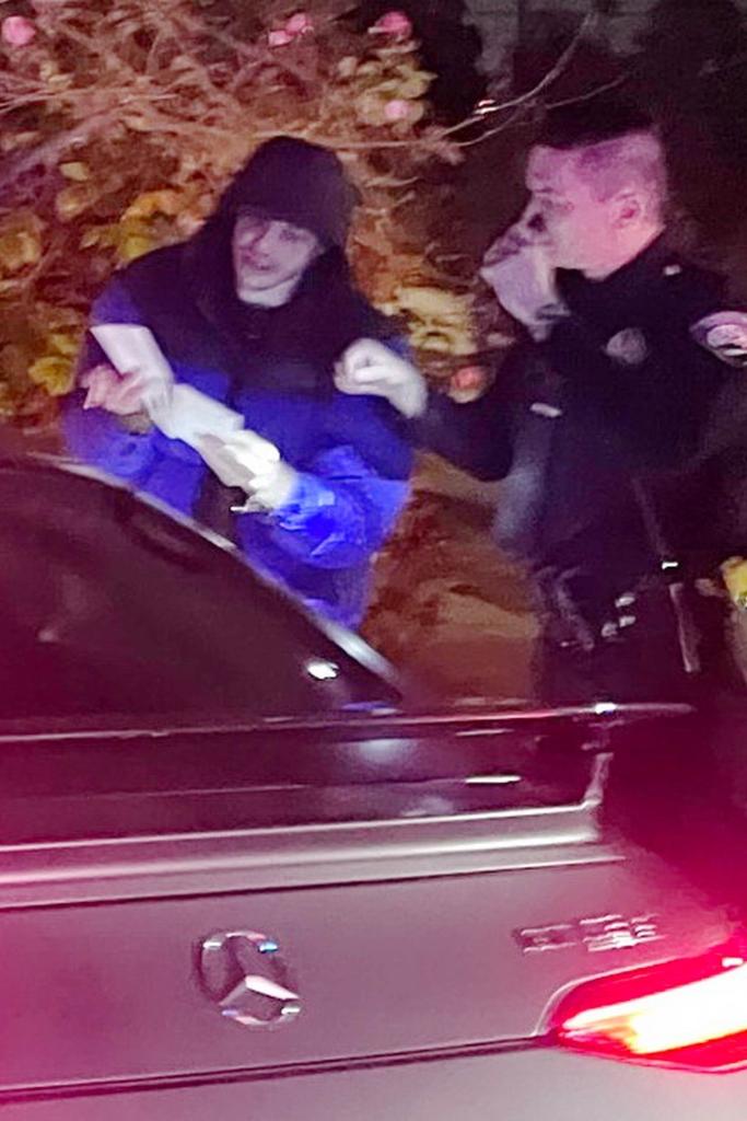 Pete Davidson showing a paper to police officers.