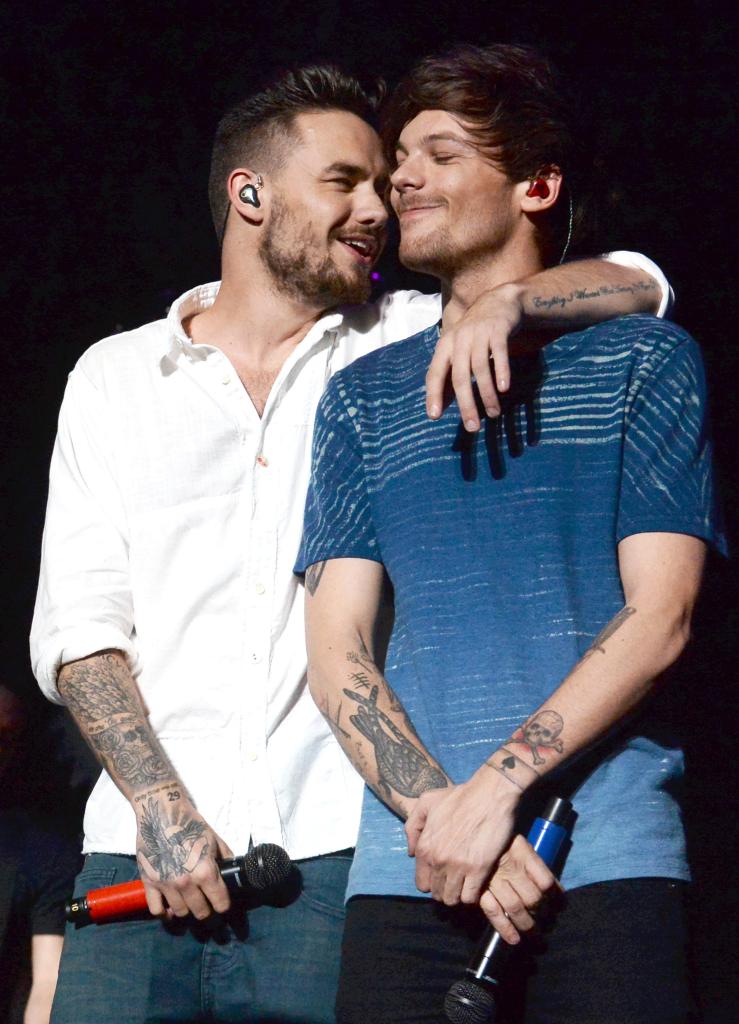 Liam Payne and Louis Tomlinson hugging onstage.