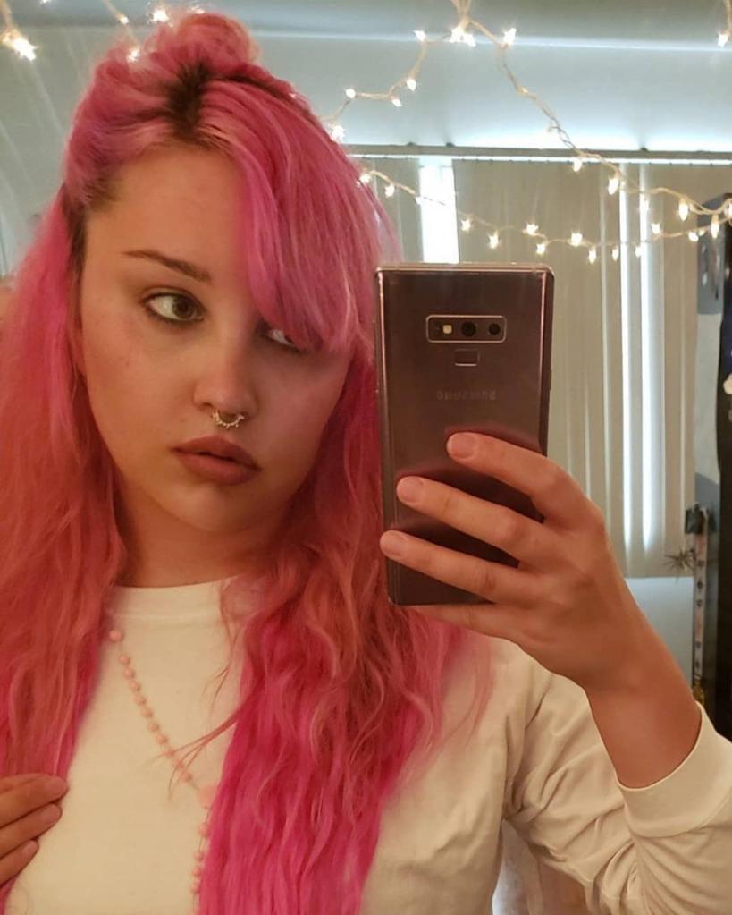 A selfie of Amanda Bynes with pink hair.