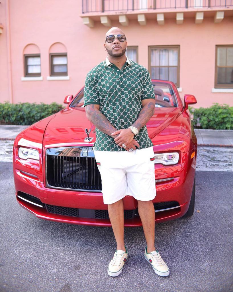 Flo Rida standing in front of a red car.