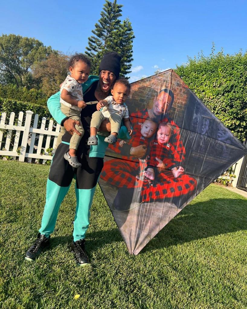 Nick Cannon with two of his kids in front of a kite.