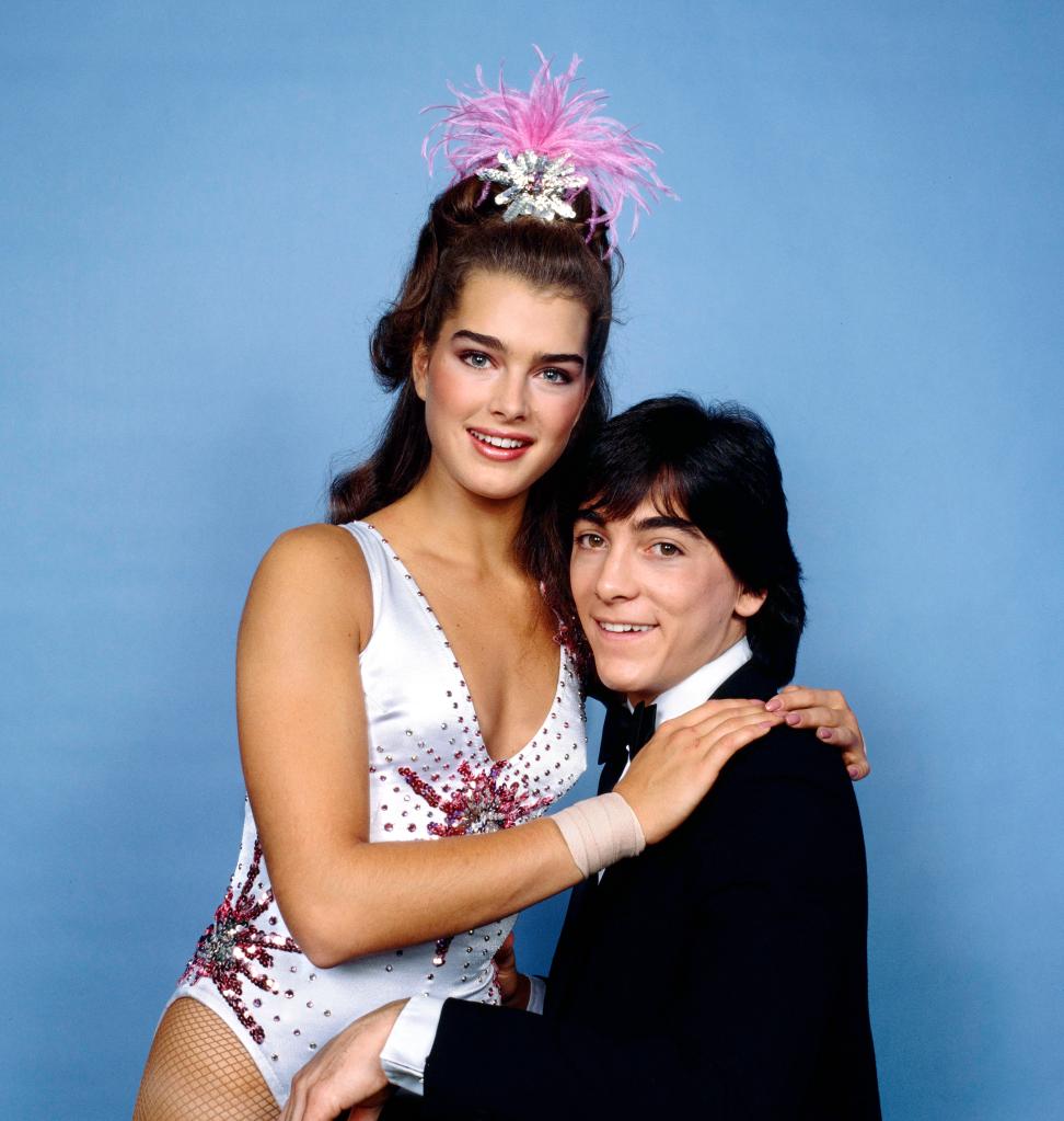 Brooke Shields sitting on Scott Baio's lap.