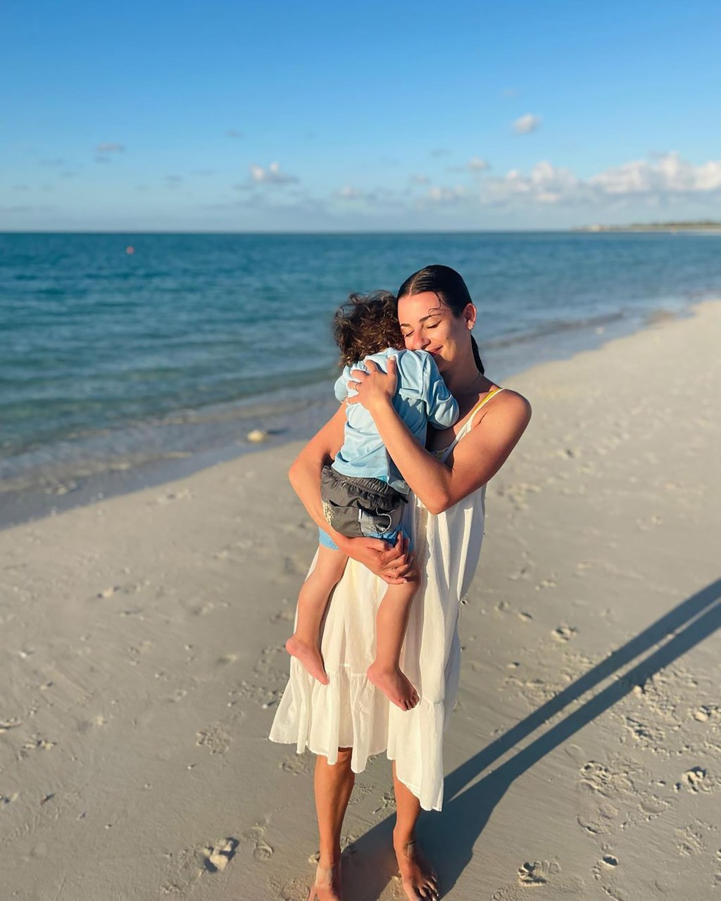 Lea Michele holding her son, Ever, at the beach.