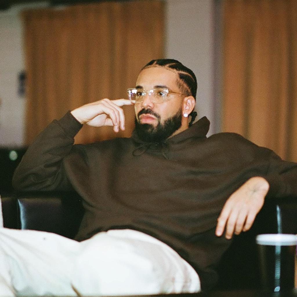 Drake with cornrows and glasses.