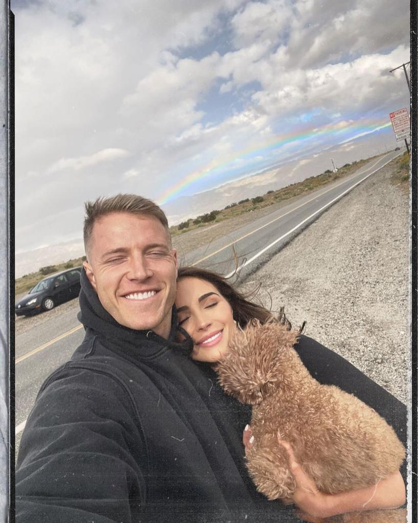 Olivia Culpo and Christian McCaffrey posing for a selfie with their dog.