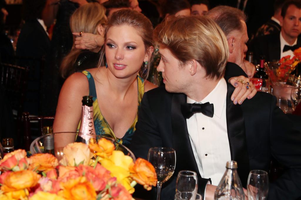 Taylor Swift and Joe Alwyn sitting at a table together.