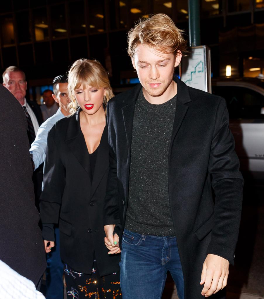 Taylor Swift and Joe Alwyn walking together and holding hands.