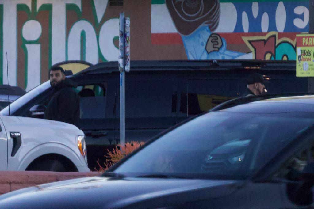 A man outside a black SUV.