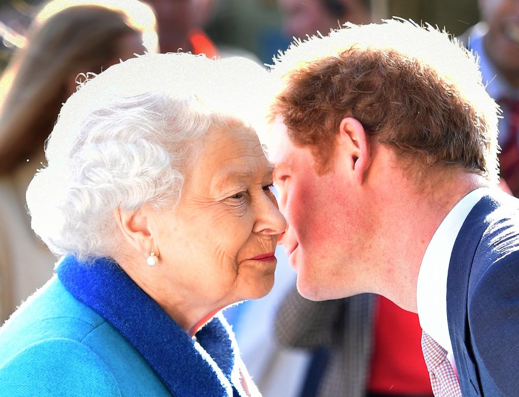 Prince Harry leaning in to give Queen Elizabeth II a kiss.