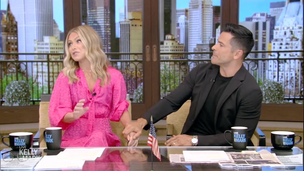 Kelly Ripa and Mark Consuelos sitting on "Live with Kelly and Mark"