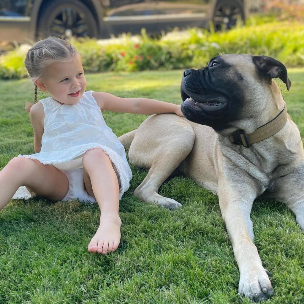 Sean Lowe's daughter, Mia, in grass with dog Gus
