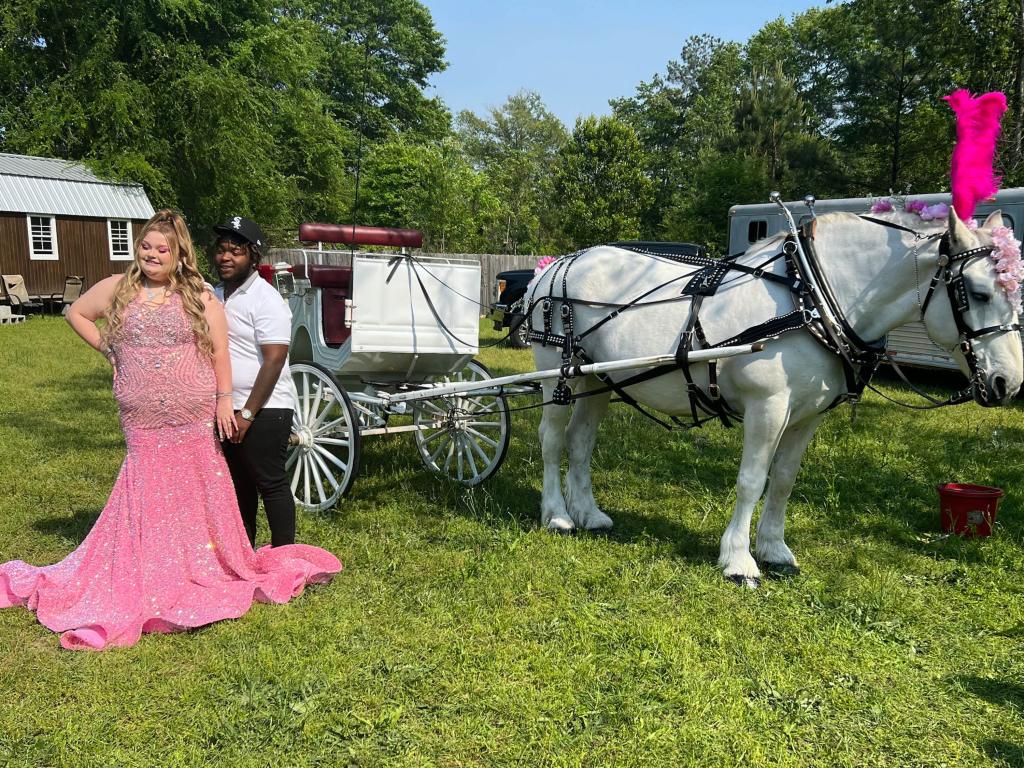 Honey Boo Boo and Darin Carswell posing for prom in front of a horse-drawn carriage