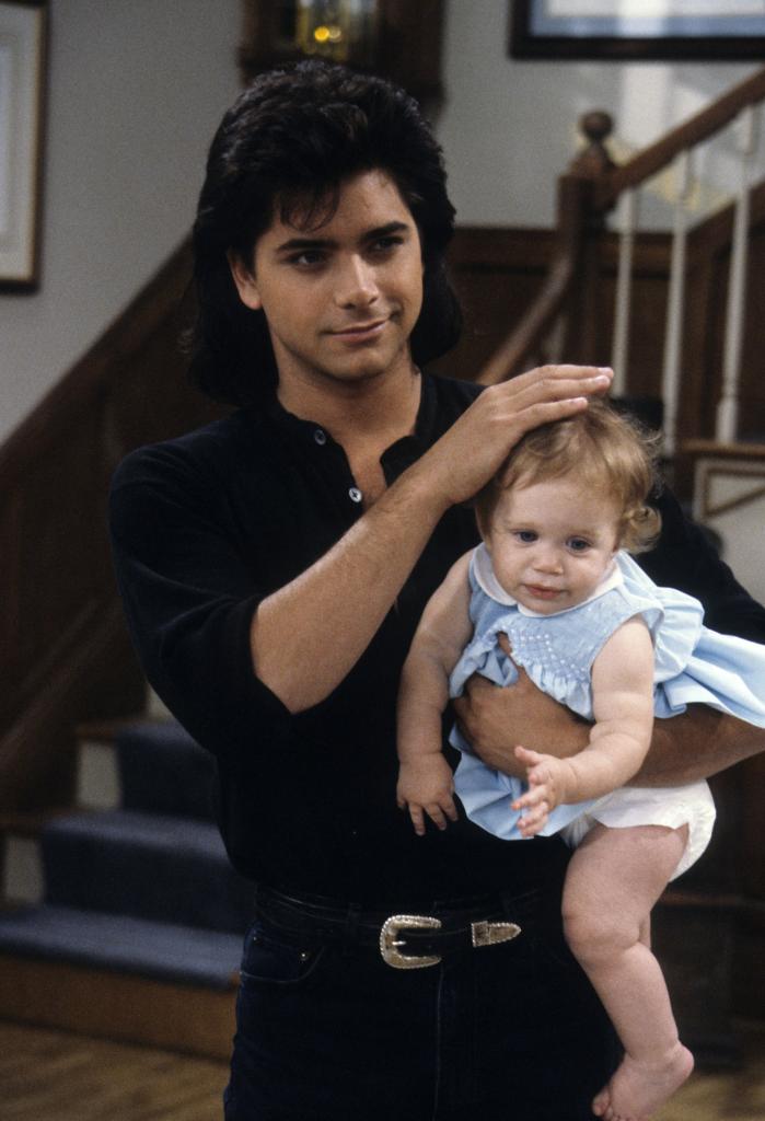 John Stamos holding one of the Olsen twins for "Full House."