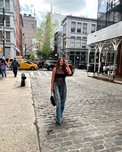 chrissy teigen posing on a cobblestone street