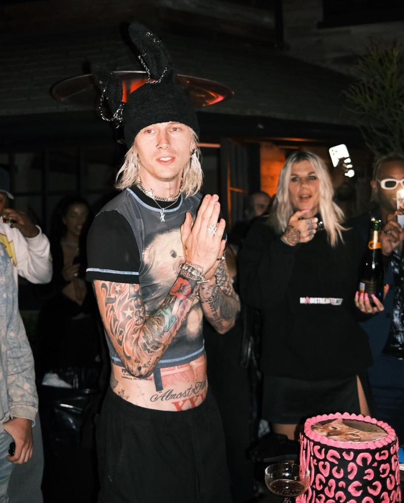 Machine Gun Kelly standing in front of his birthday cake.