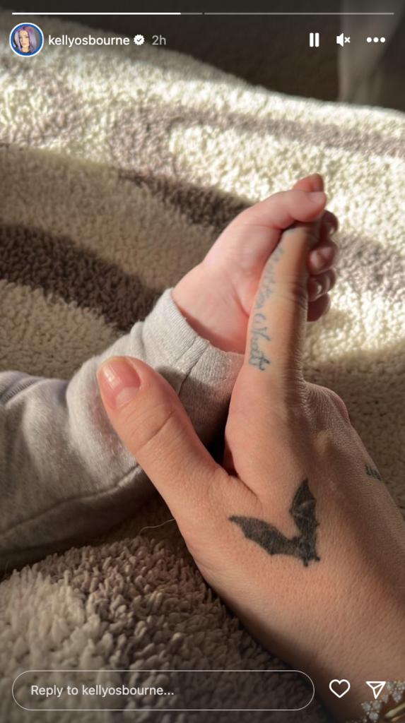 Baby Sidney grips Kelly Osbourne's index finger.