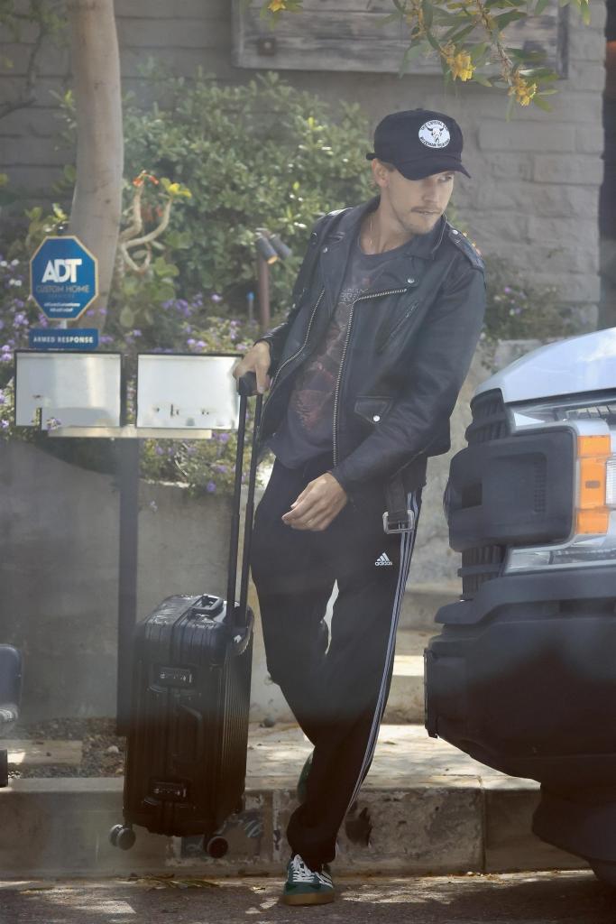 Austin Butler pushing a suitcase.