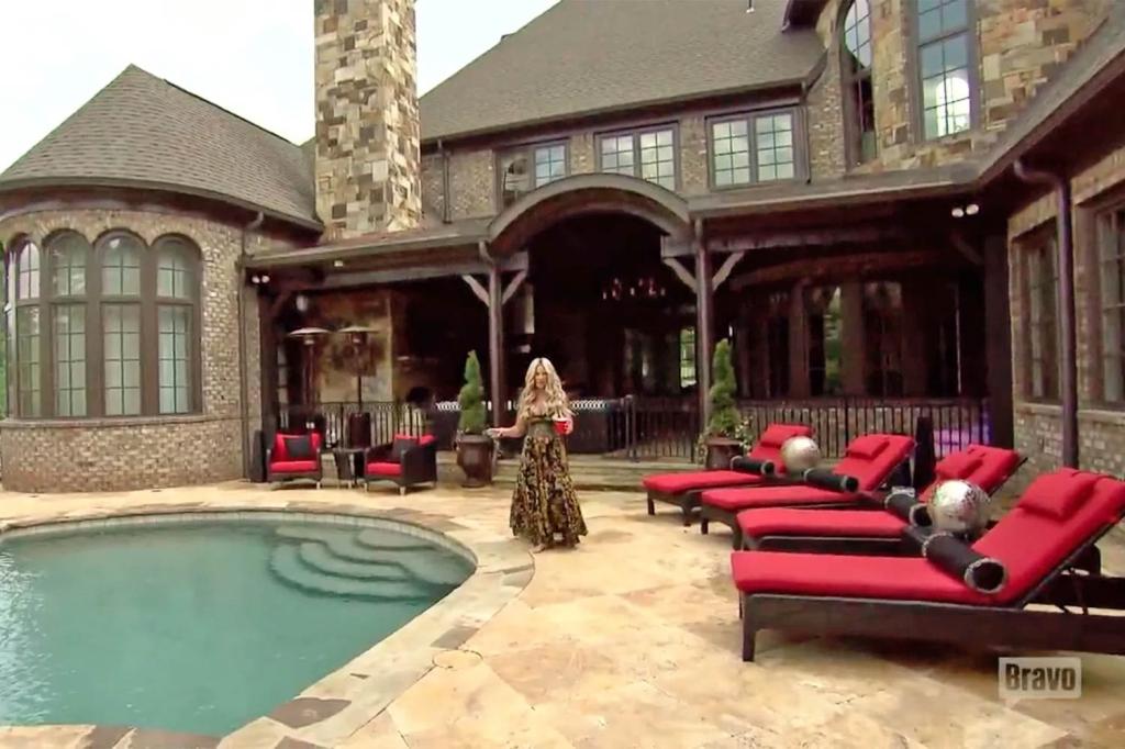 Kim Zolciak stands in front of house