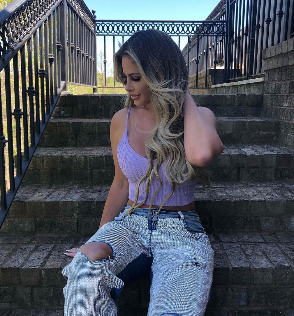 Kim Zolciak sitting on stairs.