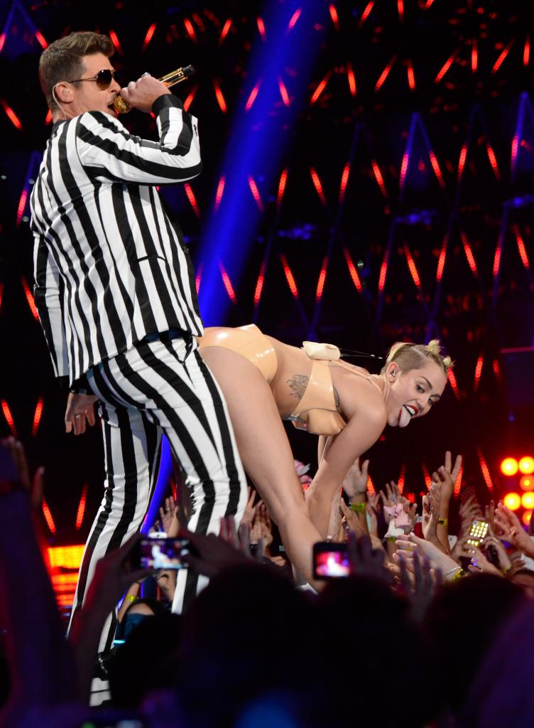 Miley Cyrus performing with Robin Thicke. 