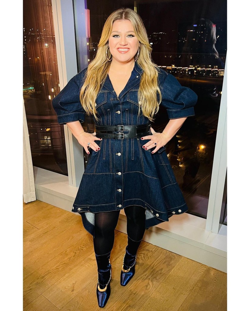 Kelly Clarkson posing in front of a window.