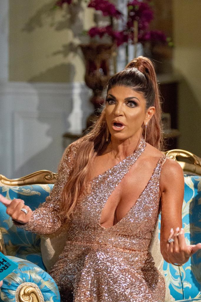 teresa giudice sitting on a couch and looking shocked